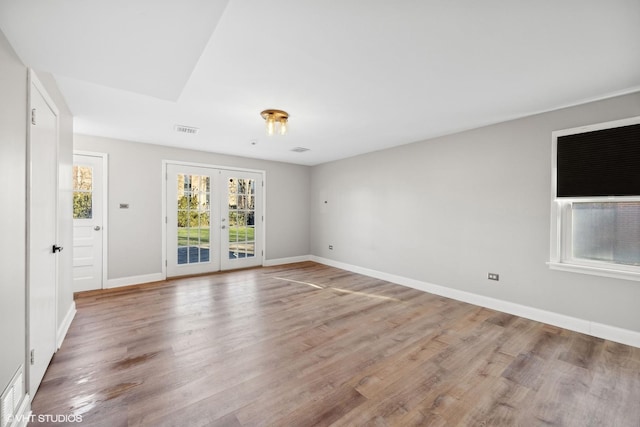 empty room with french doors and hardwood / wood-style flooring