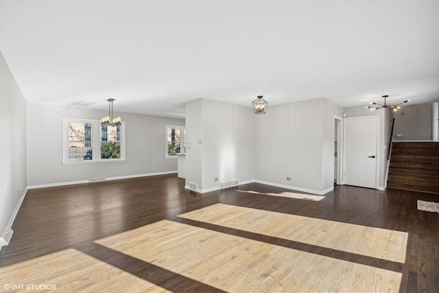 unfurnished living room with dark hardwood / wood-style flooring and a notable chandelier