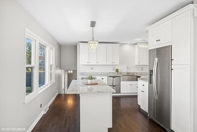 kitchen with sink, white cabinetry, decorative light fixtures, a kitchen island, and stainless steel fridge with ice dispenser