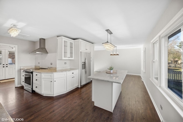 kitchen featuring white cabinetry, wall chimney exhaust hood, dark wood-type flooring, pendant lighting, and appliances with stainless steel finishes