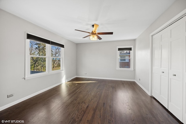 unfurnished bedroom with ceiling fan, dark wood-type flooring, and a closet