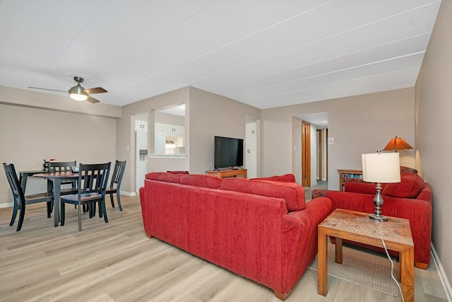 living room with light hardwood / wood-style flooring and ceiling fan