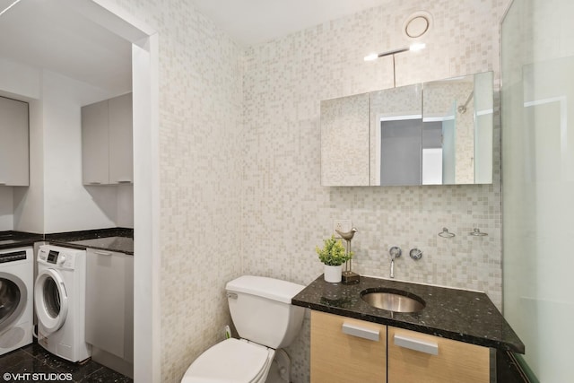 bathroom featuring toilet, backsplash, vanity, and separate washer and dryer