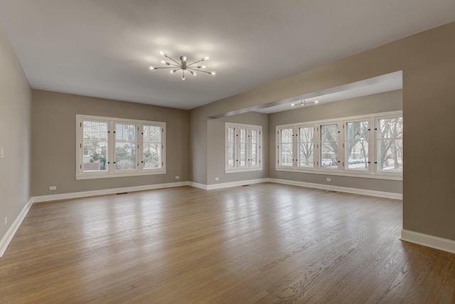 empty room with baseboards and wood finished floors