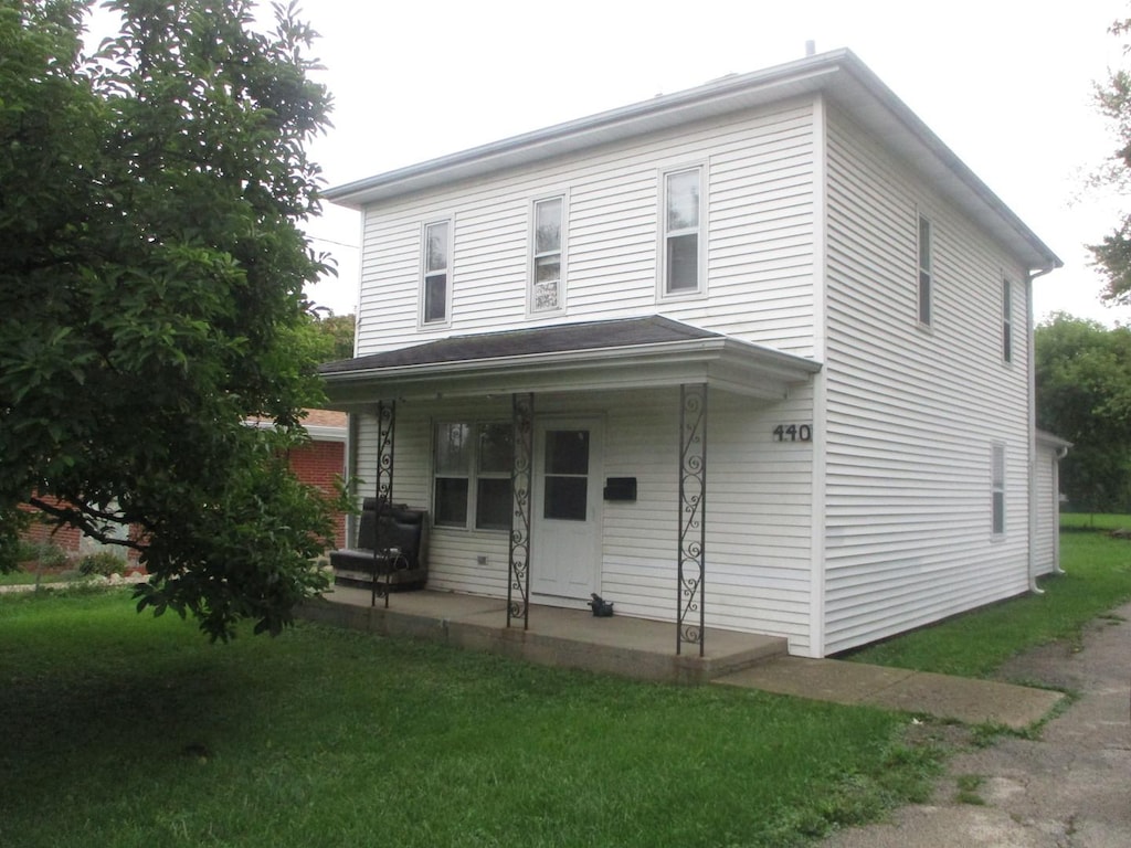 view of front of property with covered porch and a front yard