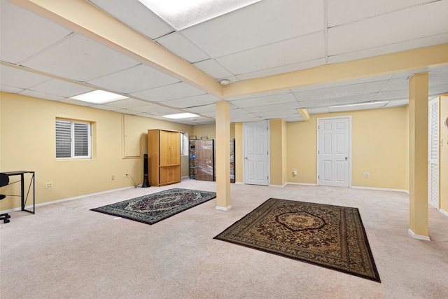 basement featuring light carpet and a drop ceiling