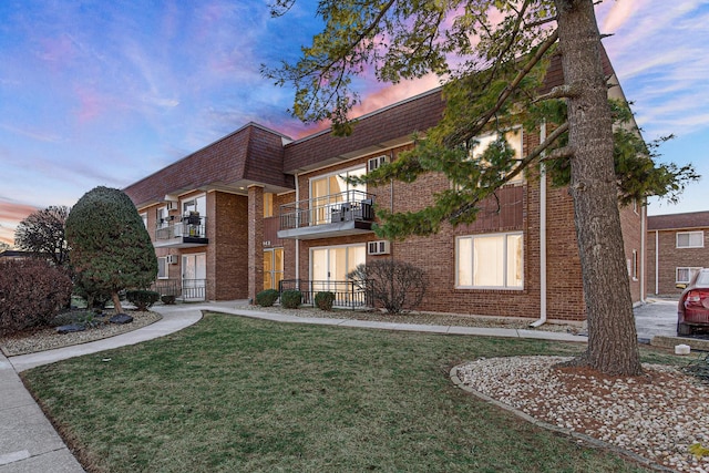 view of front of house with a balcony and a lawn