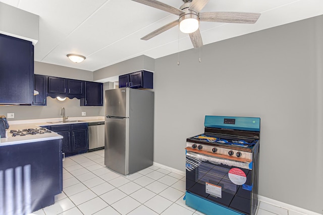 kitchen featuring sink, ceiling fan, blue cabinetry, light tile patterned flooring, and stainless steel appliances