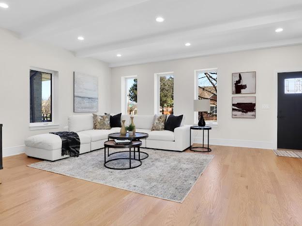 living room featuring beamed ceiling and light hardwood / wood-style floors