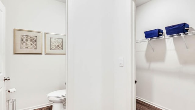 bathroom with toilet and wood-type flooring