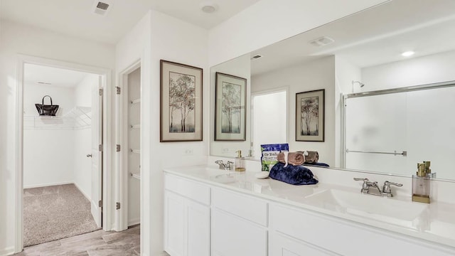 bathroom featuring walk in shower and vanity