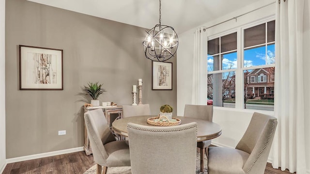 dining room featuring dark hardwood / wood-style floors and an inviting chandelier