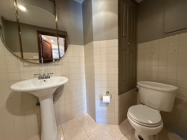 bathroom featuring toilet, tile walls, and tile patterned floors