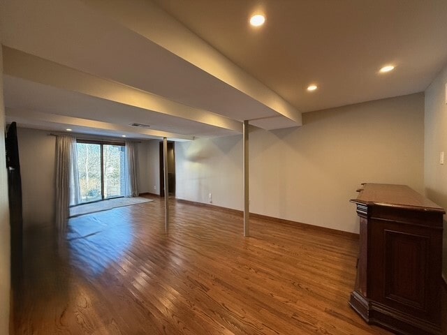 basement with wood finished floors, visible vents, and recessed lighting