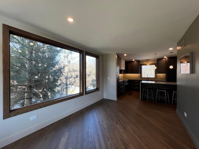 unfurnished living room with recessed lighting, dark wood finished floors, and baseboards