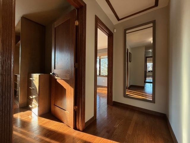 hallway with dark wood finished floors and baseboards