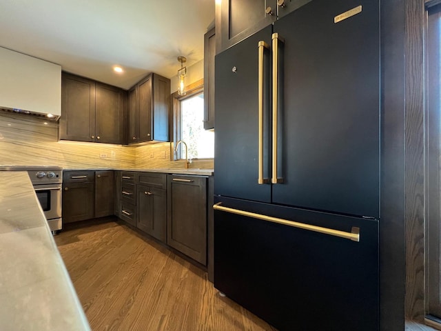 kitchen featuring high quality appliances, light countertops, a sink, and wood finished floors