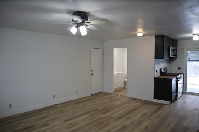 kitchen featuring ceiling fan, dark hardwood / wood-style flooring, stainless steel appliances, and tasteful backsplash