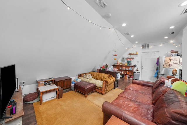 living room with light hardwood / wood-style floors and vaulted ceiling