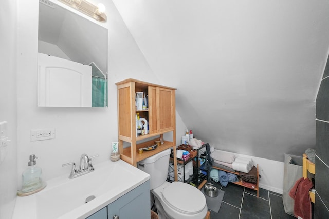 bathroom with toilet, vanity, tile patterned floors, and lofted ceiling