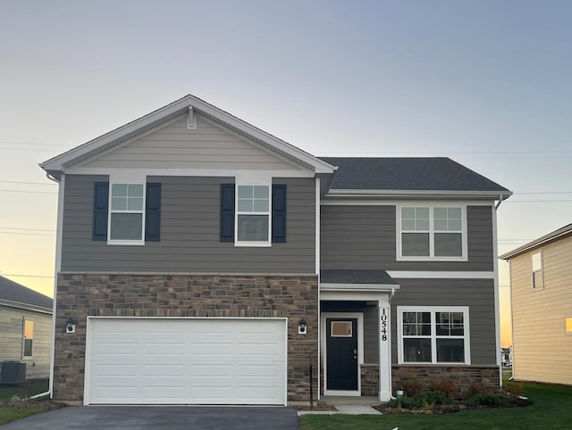 view of front of house with central air condition unit and a garage