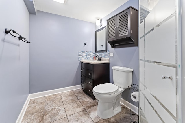 bathroom featuring vanity, toilet, and backsplash