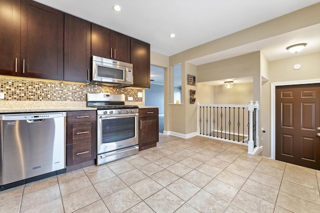 kitchen with light tile patterned floors, appliances with stainless steel finishes, and tasteful backsplash