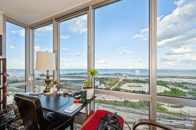 sunroom featuring a water view