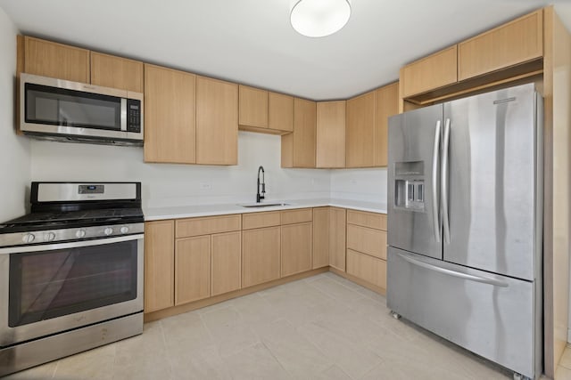 kitchen with light brown cabinetry, sink, and appliances with stainless steel finishes