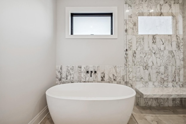 bathroom featuring tile walls and a tub to relax in