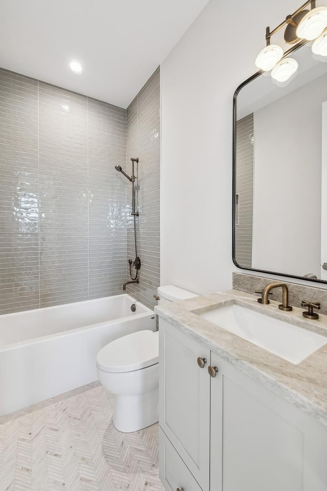 full bathroom with tiled shower / bath, vanity, and toilet