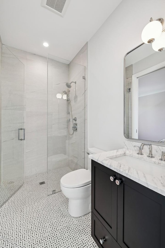 bathroom featuring tile patterned floors, vanity, toilet, and an enclosed shower