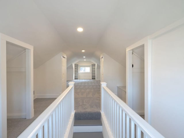 corridor featuring lofted ceiling and carpet floors