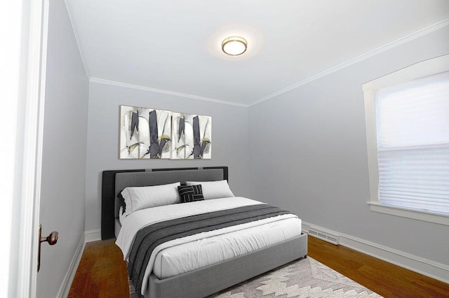 bedroom with hardwood / wood-style floors and ornamental molding