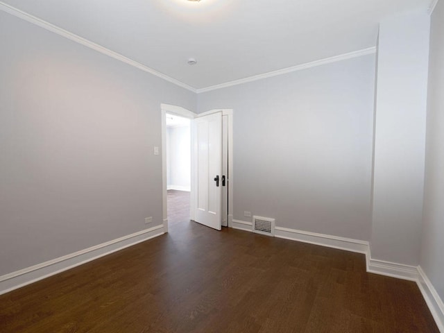 empty room with crown molding and dark hardwood / wood-style flooring