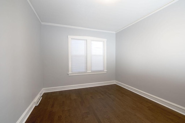 empty room with dark hardwood / wood-style flooring and crown molding