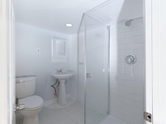 bathroom featuring a tile shower, tile patterned flooring, and toilet