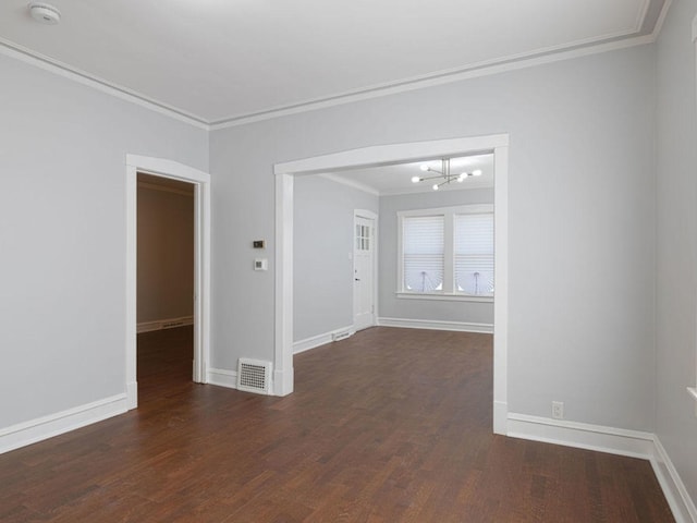 unfurnished room featuring dark hardwood / wood-style floors, ornamental molding, and a chandelier