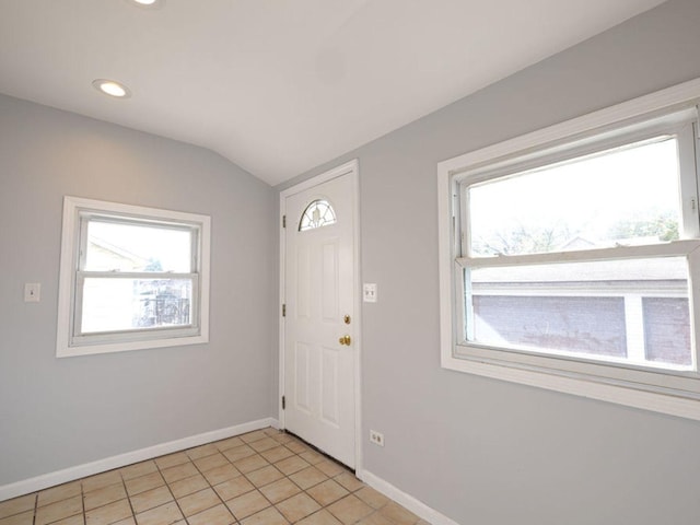 tiled foyer entrance featuring vaulted ceiling