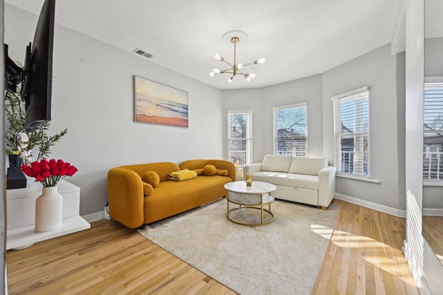 living room featuring wood-type flooring and a notable chandelier