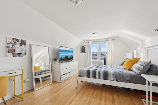 bedroom with light hardwood / wood-style flooring and lofted ceiling