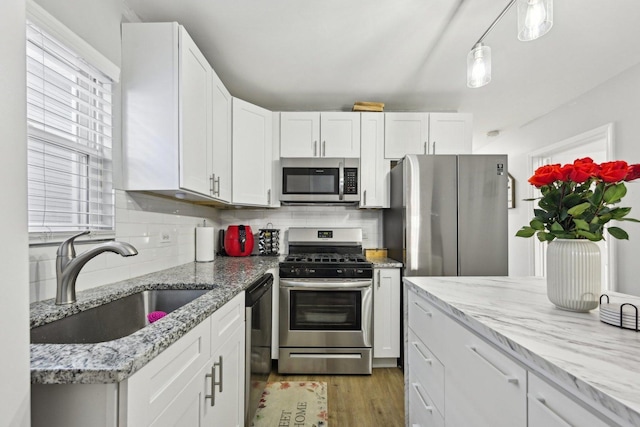 kitchen featuring sink, tasteful backsplash, white cabinetry, and stainless steel appliances