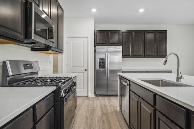 kitchen featuring light hardwood / wood-style floors, sink, dark brown cabinetry, and stainless steel appliances