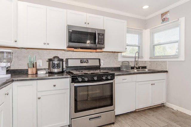 kitchen with backsplash, white cabinets, sink, light hardwood / wood-style floors, and stainless steel appliances