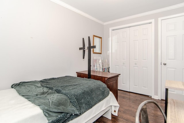 bedroom with crown molding, dark wood-type flooring, and a closet