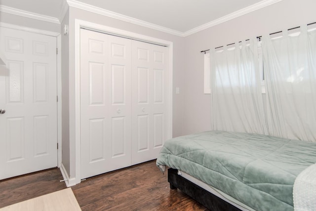 bedroom with dark hardwood / wood-style flooring, ornamental molding, and a closet