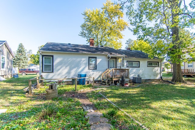 back of house with a yard and central air condition unit