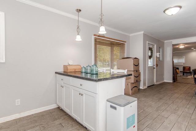 kitchen featuring white cabinetry, hanging light fixtures, kitchen peninsula, crown molding, and light wood-type flooring