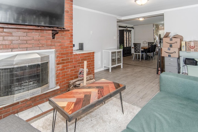 living room featuring wood-type flooring, a large fireplace, and ornamental molding