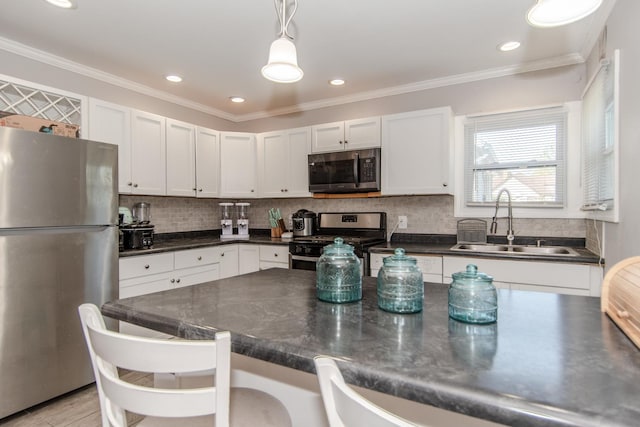 kitchen with sink, pendant lighting, a breakfast bar area, white cabinets, and appliances with stainless steel finishes